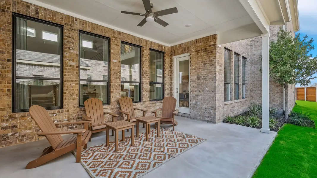 Sophisticated covered patio with brick masonry and sleek ceiling fan in Solterra, Texas.