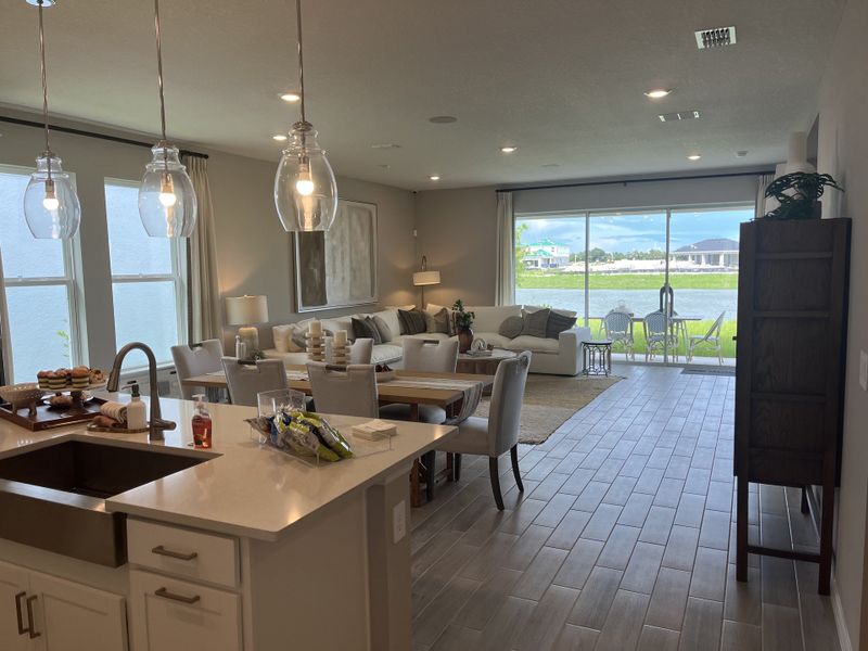 An open living space with elegant pendant lights, cozy seating, and a scenic view through large windows. An open living space with elegant pendant lights, cozy seating, and a scenic view through large windows.