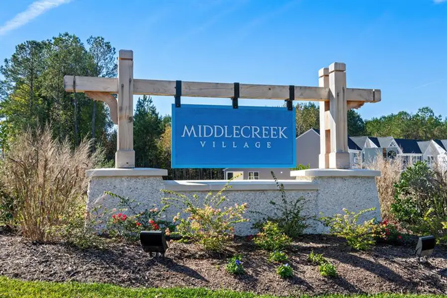 Entrance to the Middle Creek Village Coastal Cottages & Villas community in Bolivia, NC, featuring signage and landscaping (Image 1).