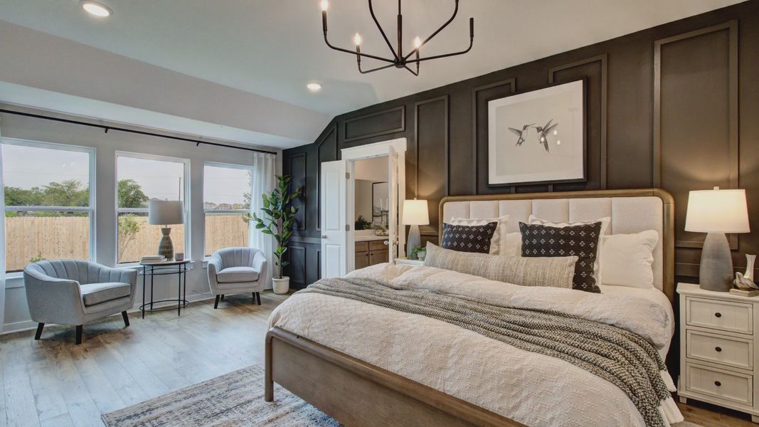 Experience luxury in Prairie Green’s bedroom, featuring rich wood floors and a stunning dark accent wall.