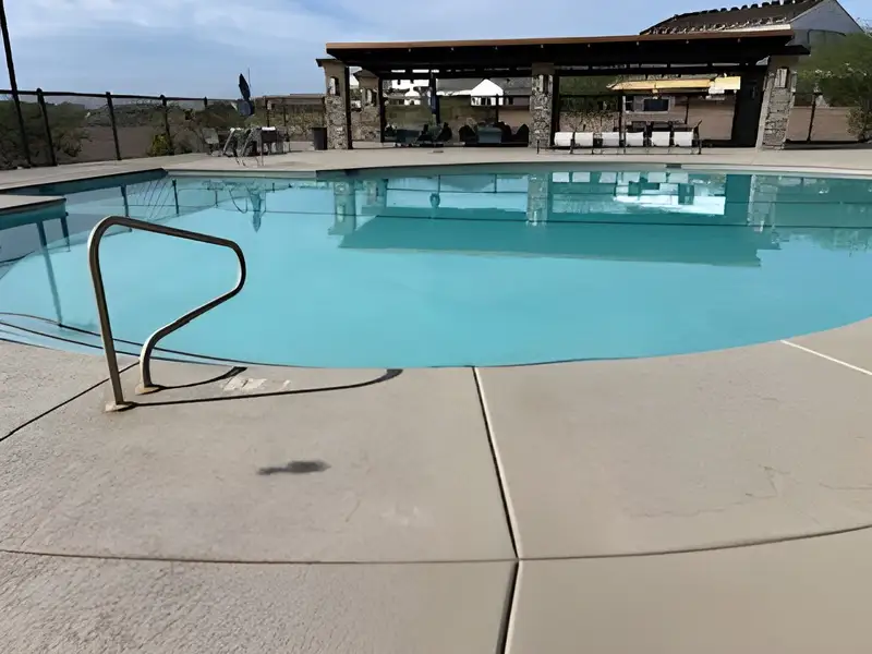 A pristine community pool with modern lounging area in Combs Ranch Discovery Collection by Taylor Morrison (Queen Creek, AZ).