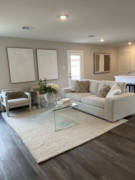 Modern living room with neutral tones, glass coffee table, and plush seating creating a cozy atmosphere.