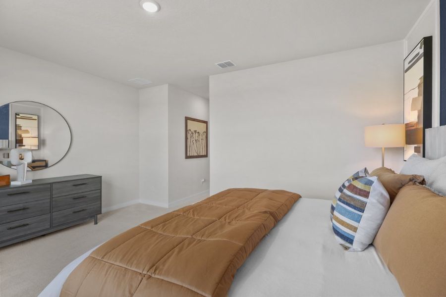 A bedroom with a bed and a mirror.