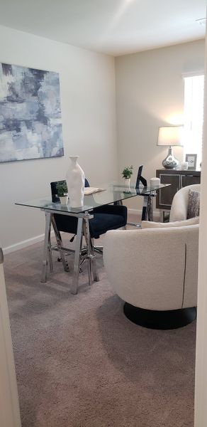 A modern home office with a glass desk, stylish decor, and cozy seating, illuminated by natural light and a chic lamp. A modern home office with a glass desk, stylish decor, and cozy seating, illuminated by natural light and a chic lamp.