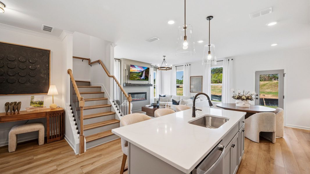 Bright open kitchen flowing into family room with island and natural light in Langley Overlook townhome in Loganville, GA. Bright open kitchen flowing into family room with island and natural light in Langley Overlook townhome in Loganville, GA.