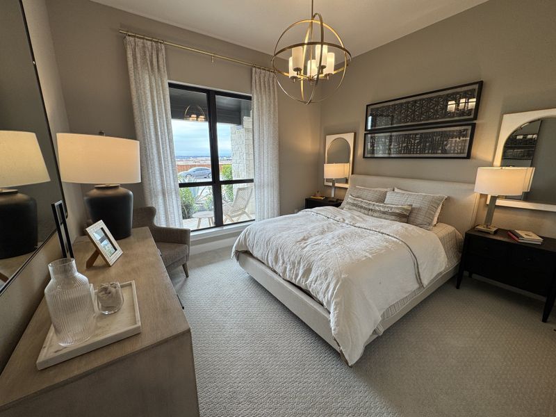 A cozy bedroom with neutral tones, elegant lighting, and a large window offering an outdoor view. A cozy bedroom with neutral tones, elegant lighting, and a large window offering an outdoor view.