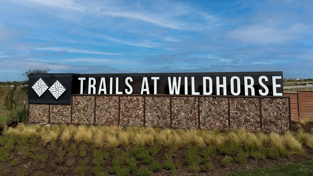 Entrance to the Trails at Wildhorse community in Austin, TX, featuring signage and landscaping (Image 1).