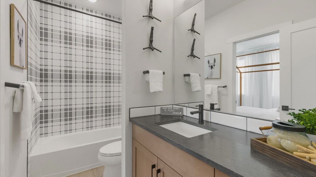 Elegant black plaid tiles and exquisite wood vanity highlight Dillon Pointe's chic bathroom design. Elegant black plaid tiles and exquisite wood vanity highlight Dillon Pointe's chic bathroom design.