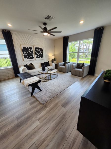 A modern living room with elegant wood flooring, stylish artwork, and comfortable seating, accented by large windows. A modern living room with elegant wood flooring, stylish artwork, and comfortable seating, accented by large windows.