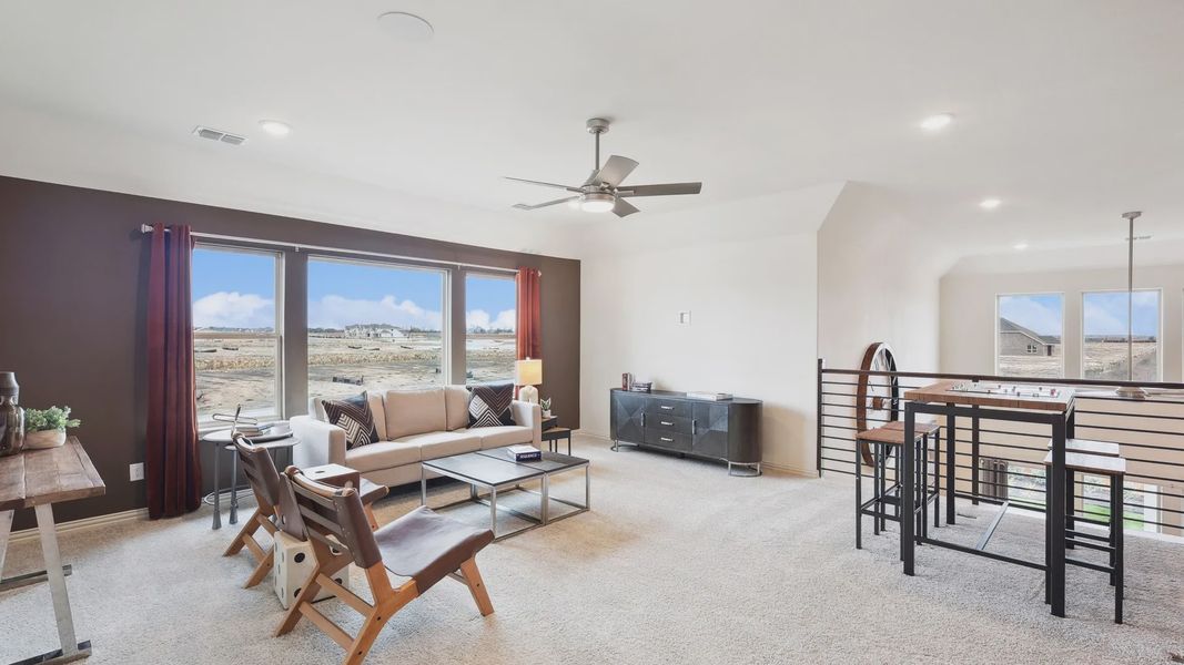 Expansive windows and sleek furnishings define this chic living space in The Oaks community.