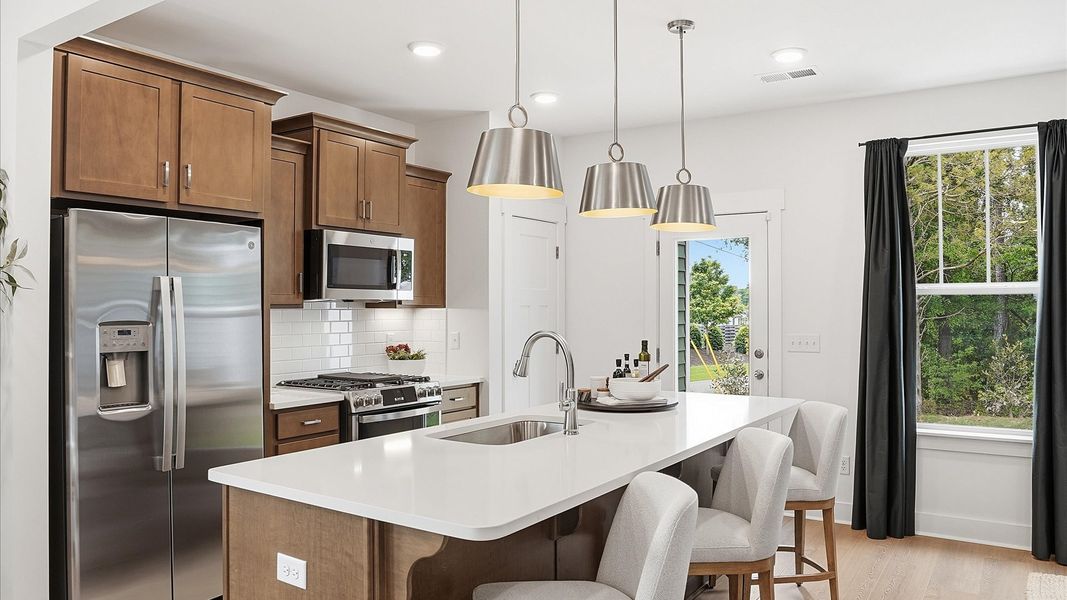 Exclusive DRB Homes kitchen with a center island, elevated finishes, and pendant lighting in a prime location Exclusive DRB Homes kitchen with a center island, elevated finishes, and pendant lighting in a prime location