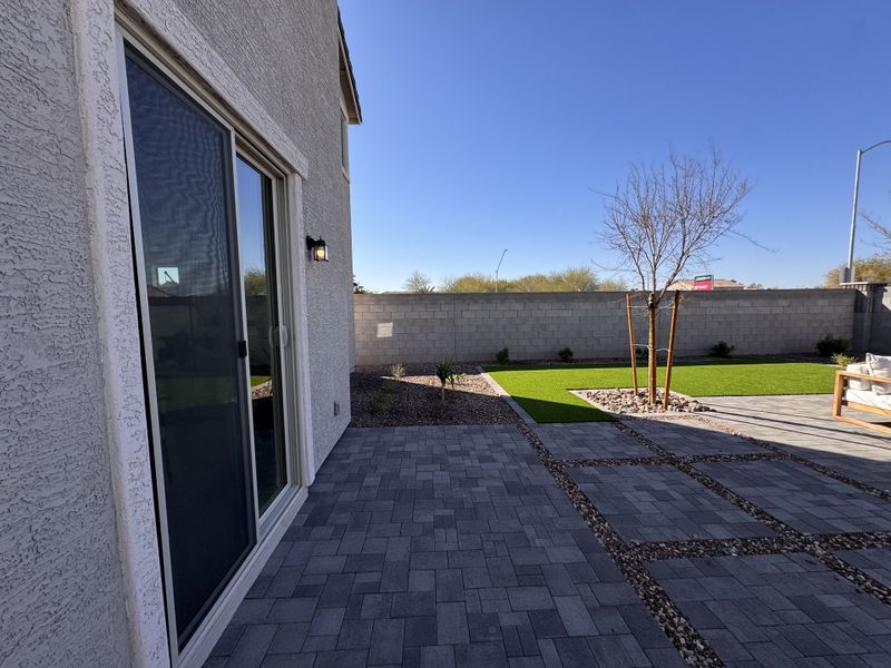 A sleek patio with paving stones and a manicured lawn in Bethany Grove by Beazer Homes (Glendale, AZ).