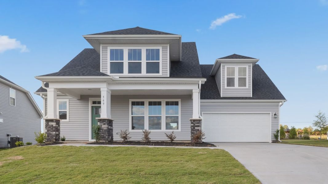 Two story home with light gray exterior, green door and stone columns at new Pinebrook community by DRB Homes in Woodruff, SC Two story home with light gray exterior, green door and stone columns at new Pinebrook community by DRB Homes in Woodruff, SC