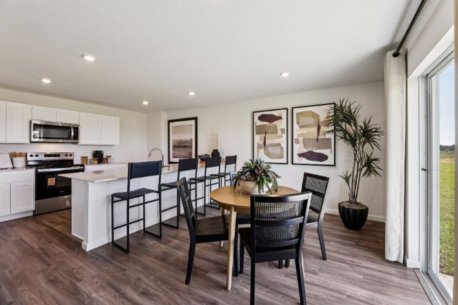A kitchen with a dining table and chairs.