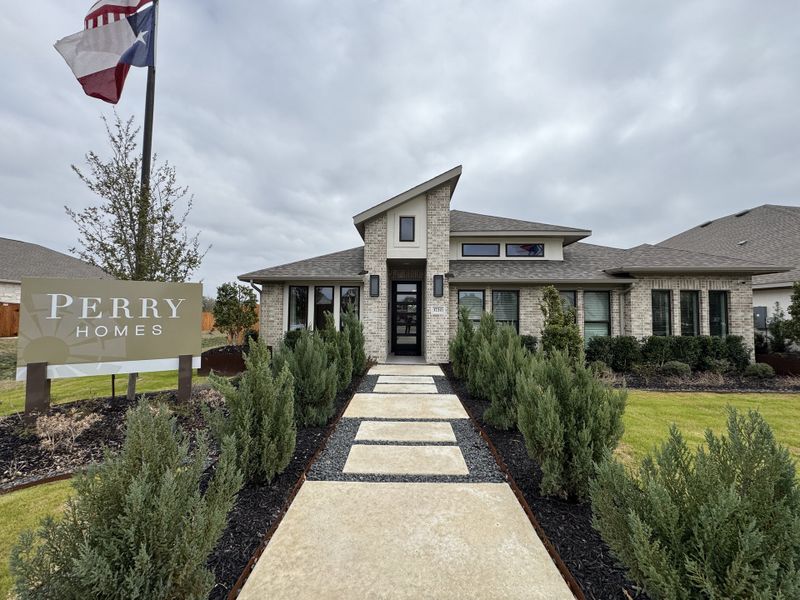 A modern brick home with a beautiful garden path in Meyer Ranch 55' by Perry Homes (Canyon Lake, TX).