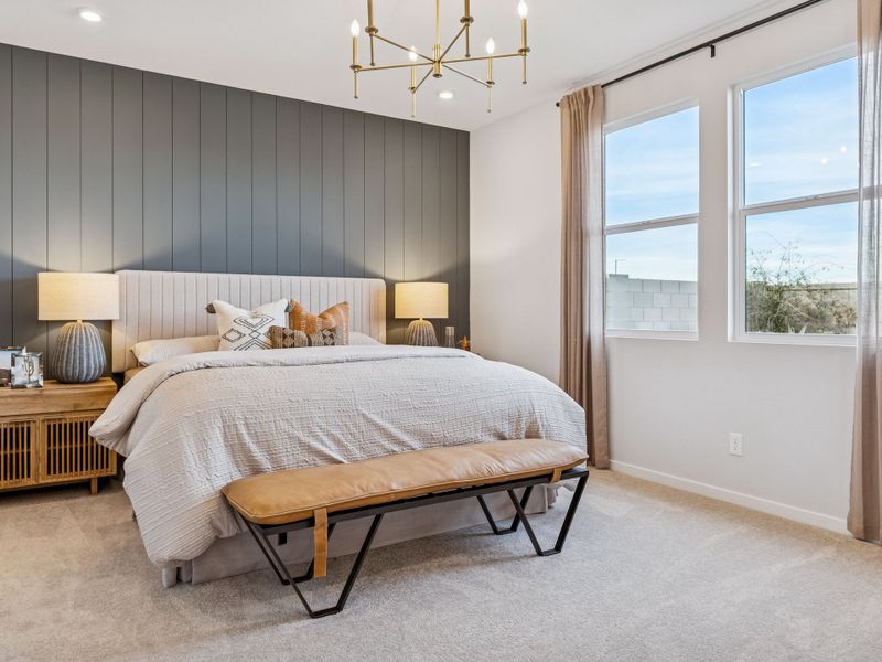 A bedroom with a bed and a bench.