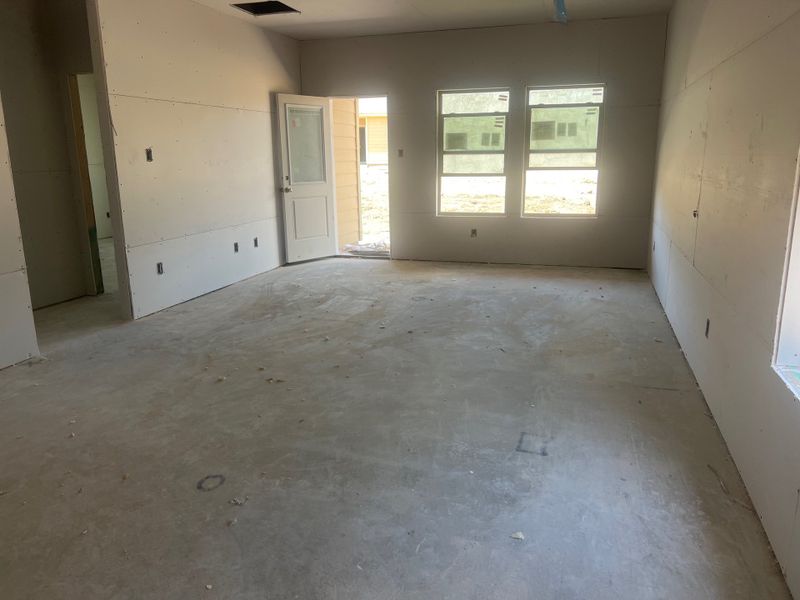 A spacious unfinished room with drywall installation and two large windows, offering abundant natural light. A spacious unfinished room with drywall installation and two large windows, offering abundant natural light.