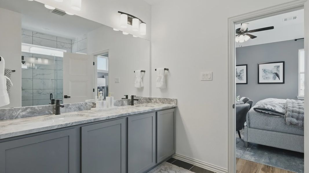 Luxurious Westridge bath features marble vanity, modern black fixtures, and a glass shower.