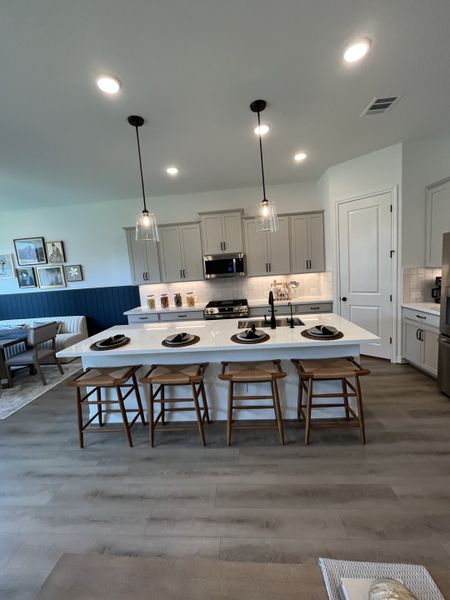 A modern kitchen with a spacious island, pendant lighting, and sleek cabinetry, perfect for cooking and entertaining. A modern kitchen with a spacious island, pendant lighting, and sleek cabinetry, perfect for cooking and entertaining.