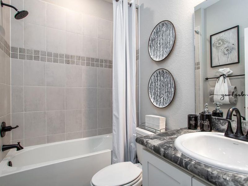 Secondary bedrooms share a hall bath with a convenient linen closet - Summerlyn model home in Winter Haven, FL