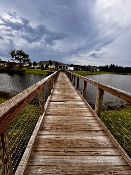 A serene wooden walkway leads to beautiful homes by the lake in RiverTown - WaterSong by Mattamy Homes (St. Johns, FL). A serene wooden walkway leads to beautiful homes by the lake in RiverTown - WaterSong by Mattamy Homes (St. Johns, FL).