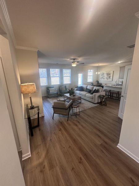 An open living area with hardwood floors, cozy seating, and ample natural light creating a welcoming atmosphere.