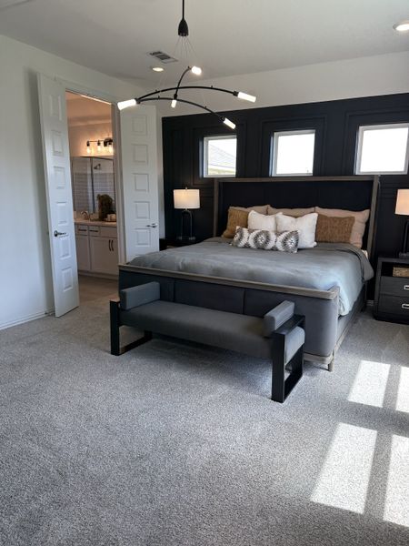 A cozy bedroom featuring a modern chandelier, sleek black accent wall, and plush carpet for a luxurious feel. A cozy bedroom featuring a modern chandelier, sleek black accent wall, and plush carpet for a luxurious feel.