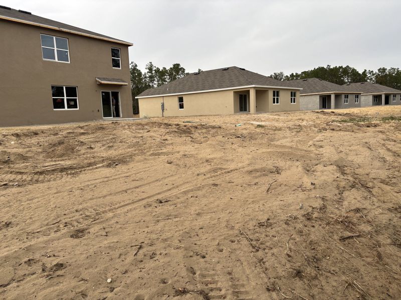 Modern homes in construction with a sandy yard in Lake Diamond by D.R. Horton (Ocala, FL).