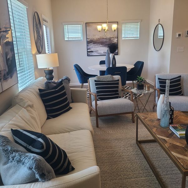 A cozy living-dining area with beige and blue tones, modern art, and stylish furnishings. A cozy living-dining area with beige and blue tones, modern art, and stylish furnishings.