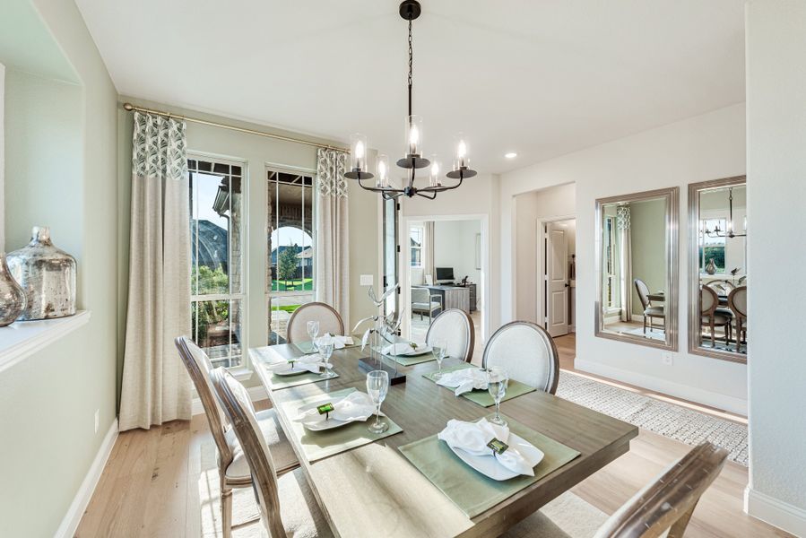 Formal dining room with set wooden table, chandelier, and large windows with backyard view Formal dining room with set wooden table, chandelier, and large windows with backyard view
