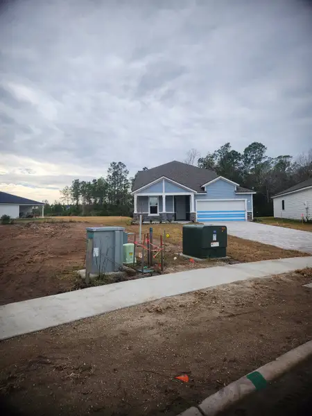 A charming single-story home with a covered entryway and fresh landscaping in Panther Creek by KB Home (Jacksonville, FL).

