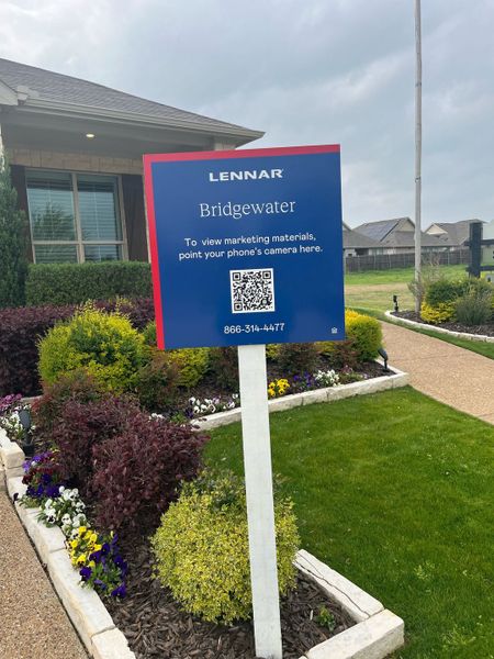 A well-kept lawn and garden in Bridgewater: Classic Collection by Lennar, Princeton, TX, featuring a modern sales sign.