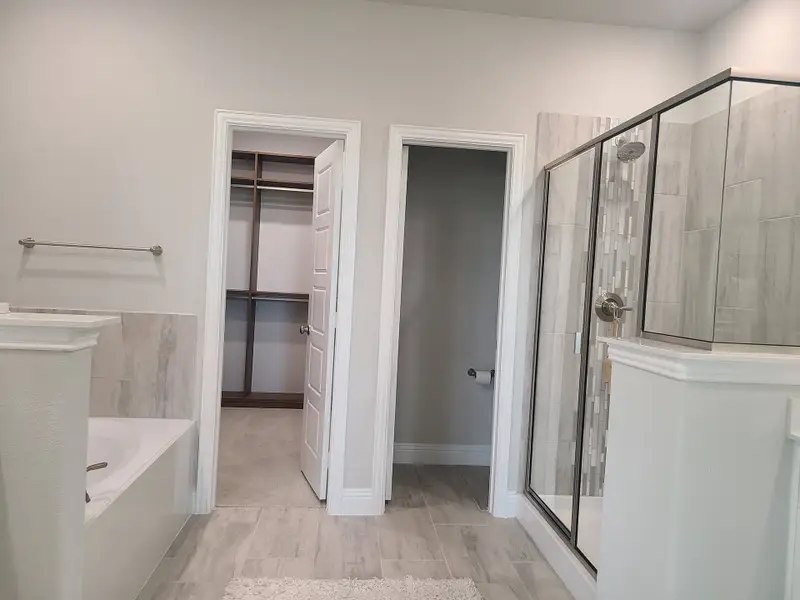 A modern bathroom with a spacious glass shower, elegant tiles, and a walk-in closet for added convenience. A modern bathroom with a spacious glass shower, elegant tiles, and a walk-in closet for added convenience.