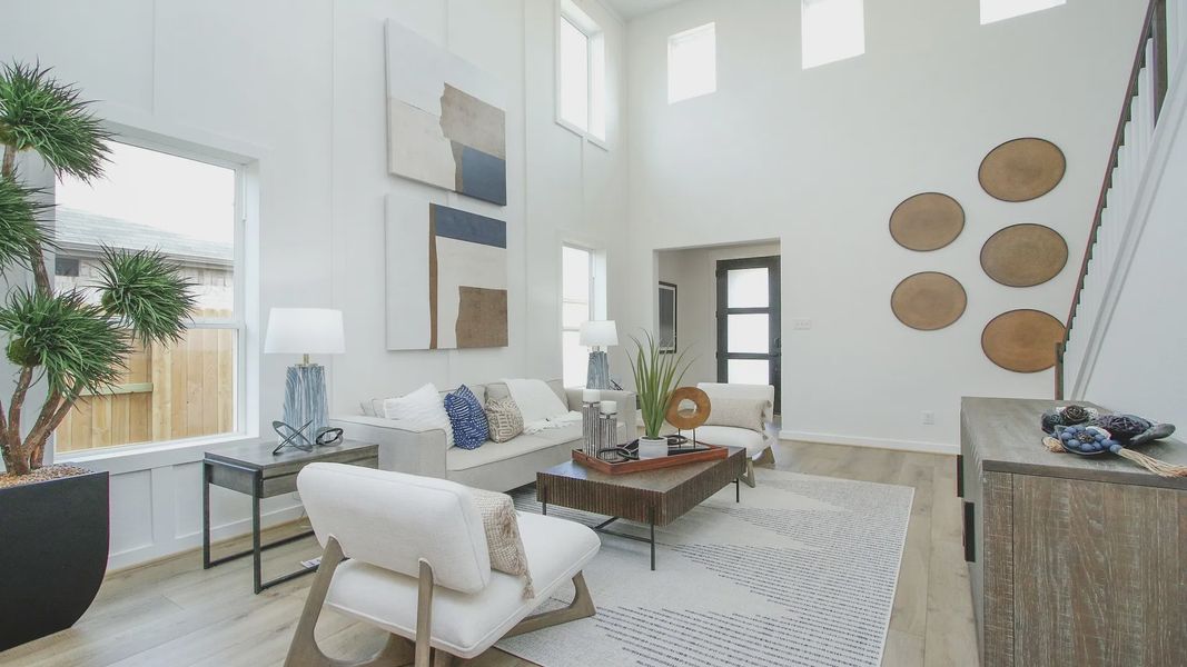 Soaring ceilings and elegant wood accents define this stylish Colony at Pinehurst, Texas living room.