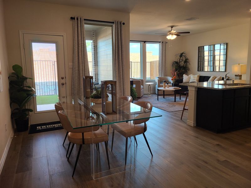An elegant open-plan living area featuring a glass dining table, cozy seating, and natural light, perfect for modern living. An elegant open-plan living area featuring a glass dining table, cozy seating, and natural light, perfect for modern living.
