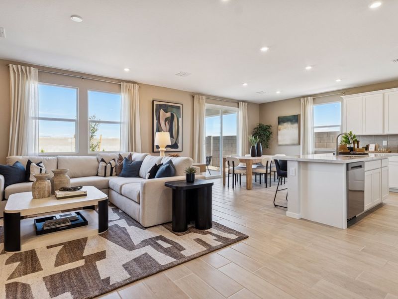 A large living room with a large rug and a large window.