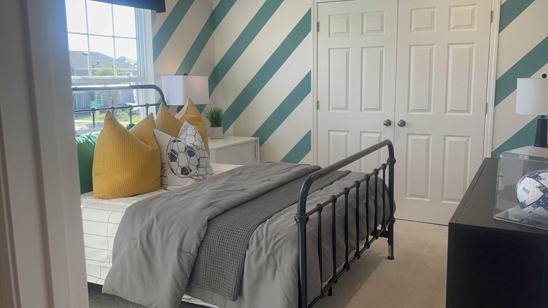 A cozy bedroom with a modern striped accent wall, decorative pillows, and a sleek black metal bed frame. A cozy bedroom with a modern striped accent wall, decorative pillows, and a sleek black metal bed frame.
