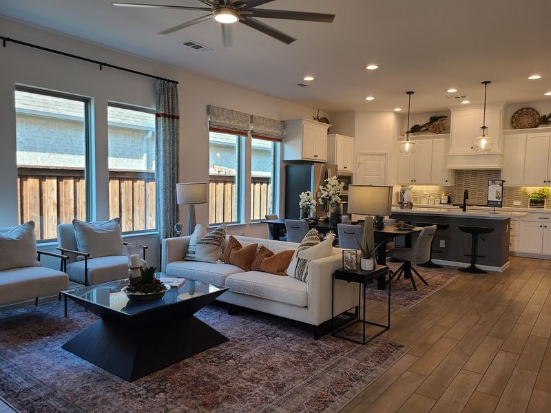 A cozy open-concept living area with sleek kitchen, warm lighting, and modern decor. A cozy open-concept living area with sleek kitchen, warm lighting, and modern decor.