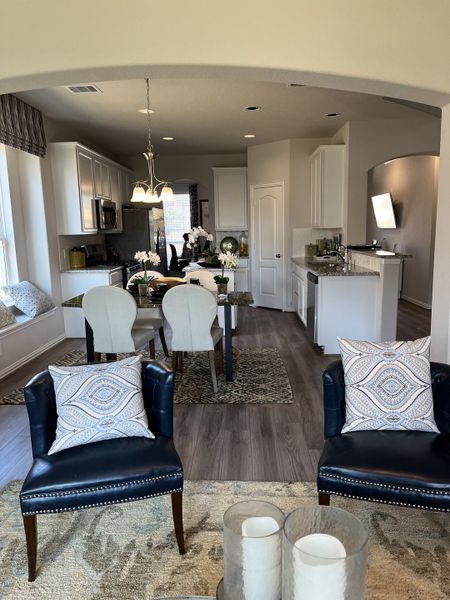 A welcoming living and dining area with modern decor, plush seating, and an inviting kitchen setup. A welcoming living and dining area with modern decor, plush seating, and an inviting kitchen setup.