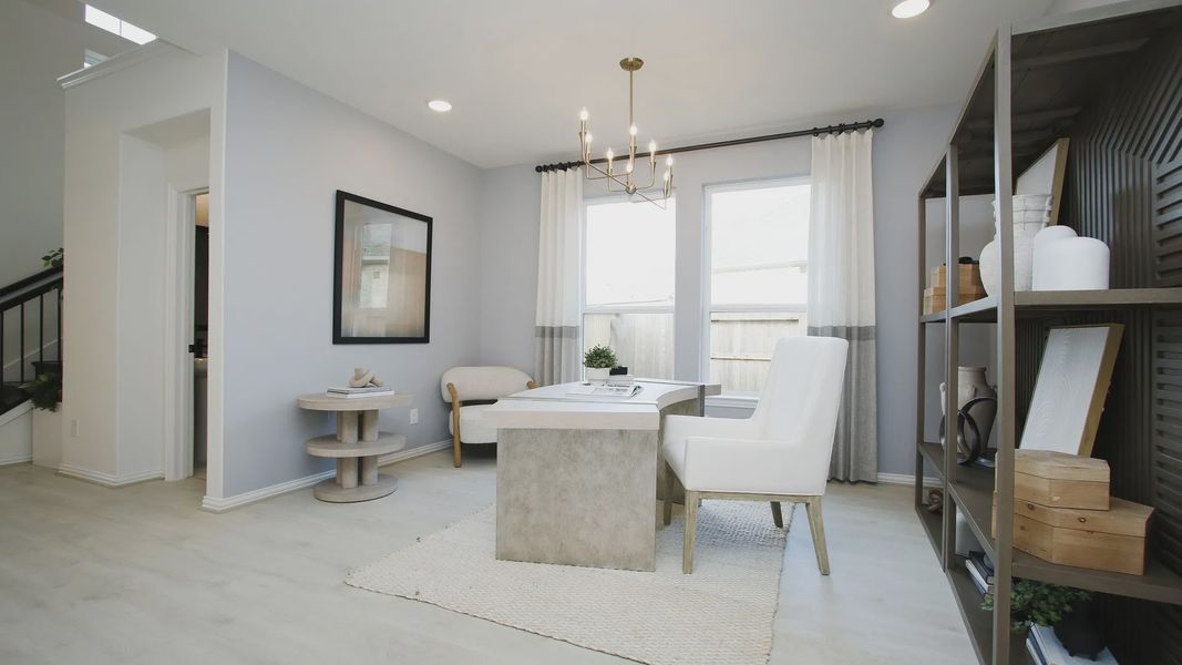 Luxurious office space with chic chandelier, expansive windows, and sleek shelving in The Woodlands Hills.