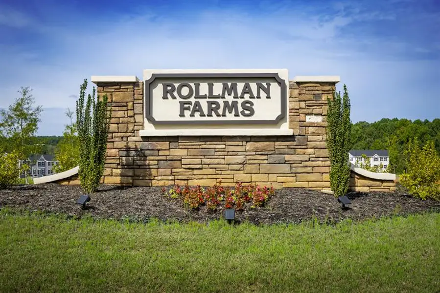 Entrance to the Rollman Farms Townhomes community in Raleigh, NC, featuring signage and landscaping (Image 1).