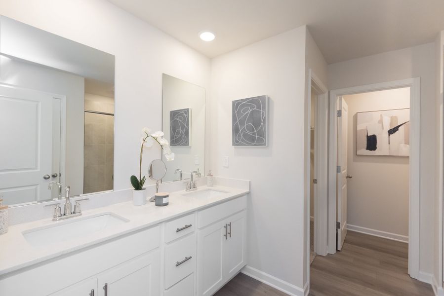 The ensuite bathroom features dual-vanity sinks and a walk-in closet.