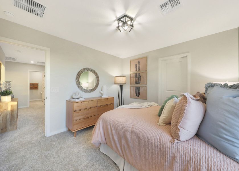 A bedroom with a bed and a mirror.
