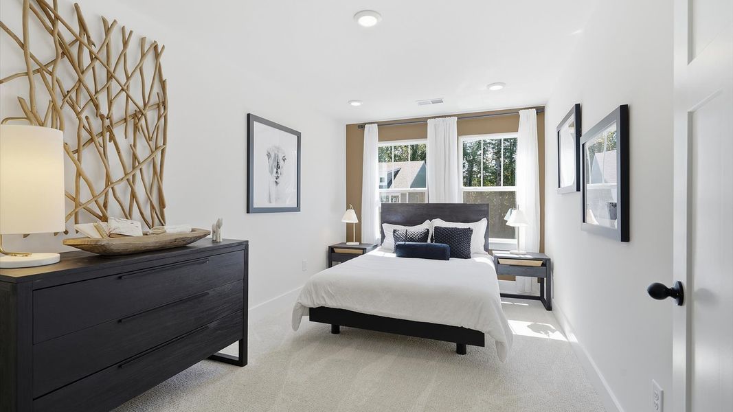 Highly functional bedroom with large windows, carpeted flooring, and tasteful finishes throughout by DRB Homes