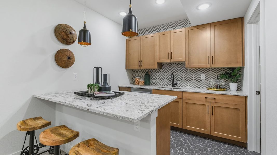 Elegant kitchen with bespoke wood cabinetry and premium herringbone tiles in Dillon Pointe, showcasing refined design. Elegant kitchen with bespoke wood cabinetry and premium herringbone tiles in Dillon Pointe, showcasing refined design.