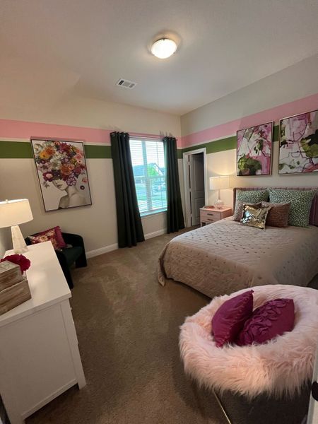 A vibrant bedroom featuring colorful artwork, plush accents, and a cozy bed with decorative pillows. A vibrant bedroom featuring colorful artwork, plush accents, and a cozy bed with decorative pillows.