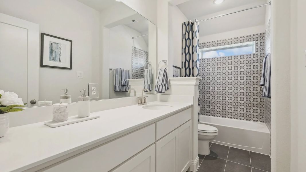 Luxurious bathroom features striking geometric tile and sleek fixtures in Ridge Crossing. Luxurious bathroom features striking geometric tile and sleek fixtures in Ridge Crossing.
