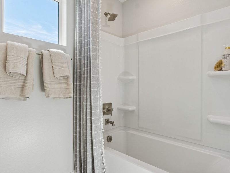 A bathroom with a bathtub and towels.
