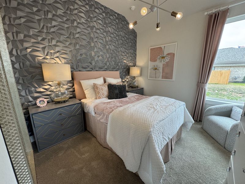 A chic bedroom with textured wallpaper, cozy bedding, stylish lighting, and elegant decor accents.