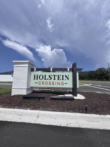 Holstein Crossing community entrance sign with landscaped surroundings in Holstein Crossing: Holstein Crossing 50s by Lennar (Green Cove Springs, FL).